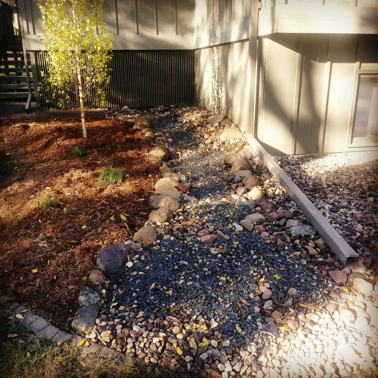 The drainage area along this house becomes an interesting element with a creek bed design.